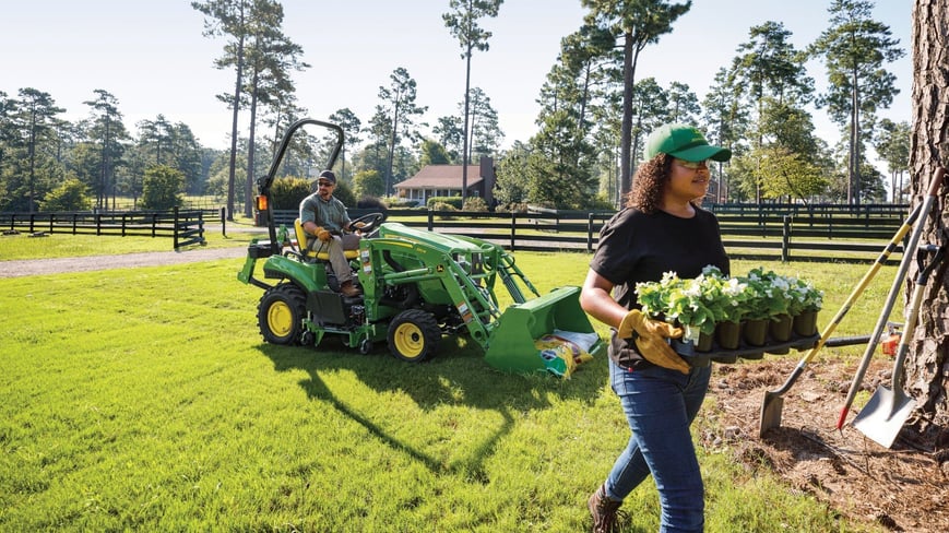 compact utility tractor being used in a residential landscaping setting