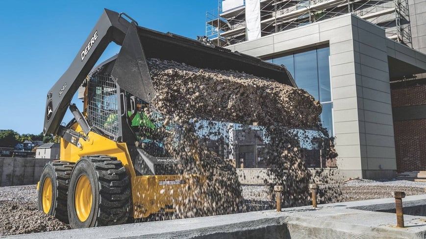 Skid Steer dumping gravel on a construction site