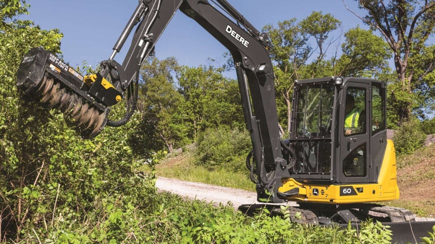 Compact Excavator moving branches 